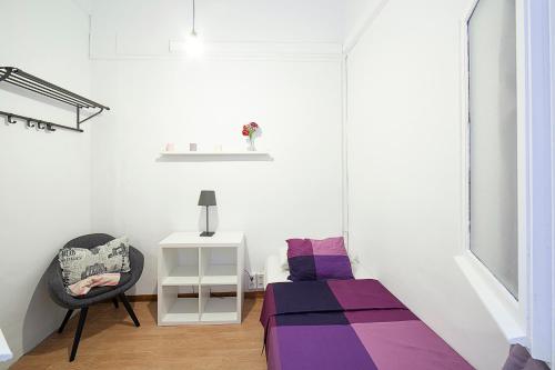 a room with a bed, a chair, and a rug at Fabrizzios Terrace Hostel in Barcelona