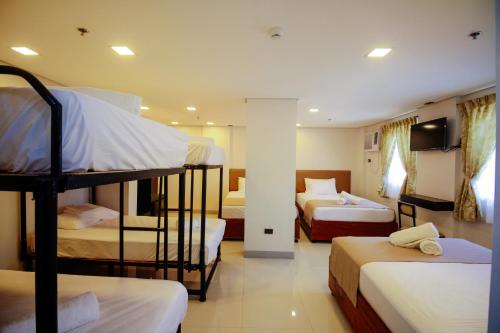 um quarto com três beliches num hotel em Belltower CSheLi Suites em Vigan