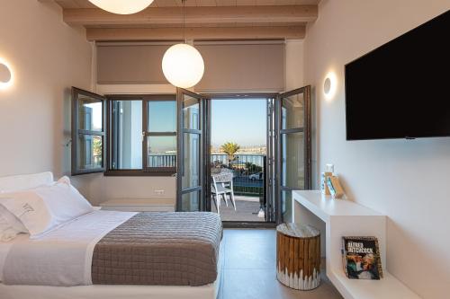 una camera da letto con un letto e una TV a schermo piatto di V77 Seafront Suites a Rethymno