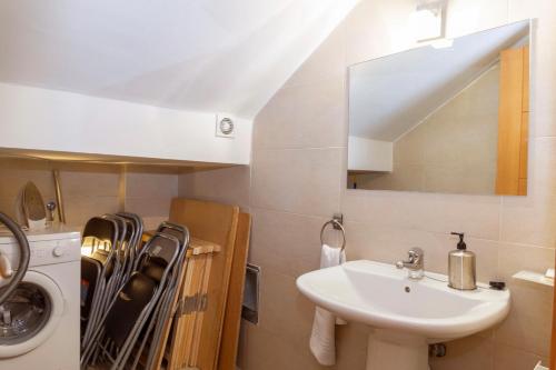 a bathroom with a sink and a washing machine at Apartamento Abuela Benita in Cebreros