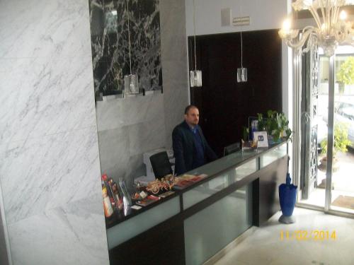 a man standing at a counter in a restaurant at Rigel Hotel in Catania
