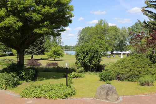a park with a light on the grass and trees at Seepark Hotel am Wandlitzsee in Wandlitz