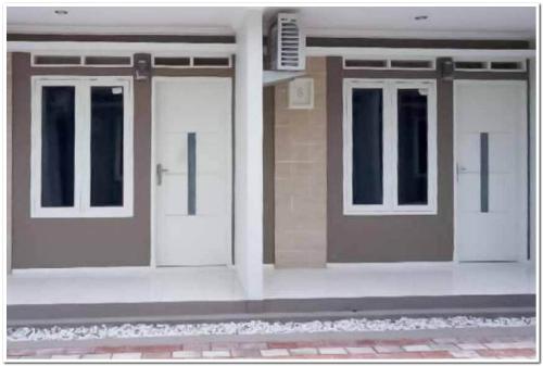 une paire de portes sur le côté d'un bâtiment dans l'établissement Syukur Guesthouse Syariah RedPartner, 