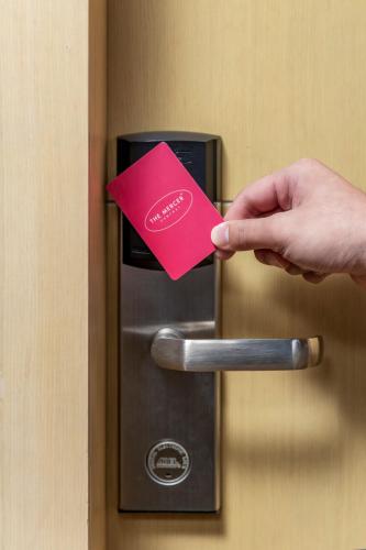 a person holding a pink card on a door at The Mercer in Hong Kong