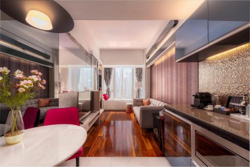 香港的住宿－The Mercer，一间厨房和一间带红色椅子及桌子的客厅