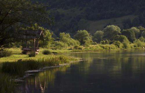 a bench next to a body of water at Domacinstvo na kraju svijeta in Šipovo