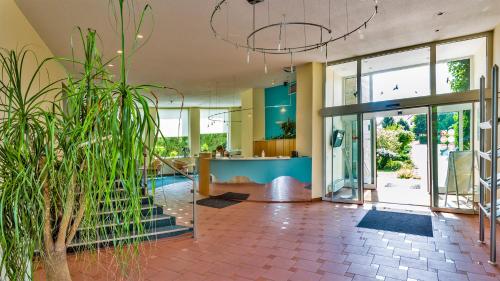 a lobby with glass doors and potted plants at Seepark Hotel am Wandlitzsee in Wandlitz