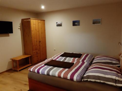 um quarto com uma cama e um armário de madeira em Pension Lehmann em Radebeul