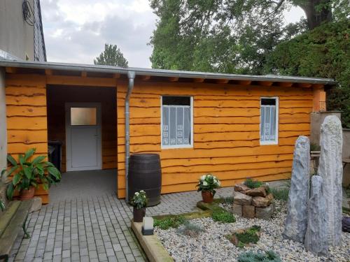 eine Holzhütte mit einer Tür und einer Terrasse in der Unterkunft Pension Lehmann in Radebeul