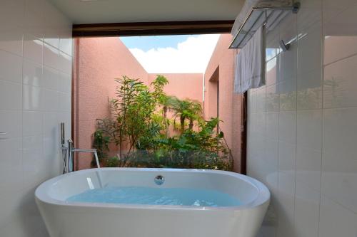 a bath tub in a bathroom with a window at The Shigira in Miyako-jima