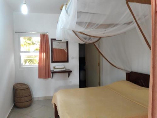 una camera con letto a baldacchino e finestra di Town Center Apartments a Watamu