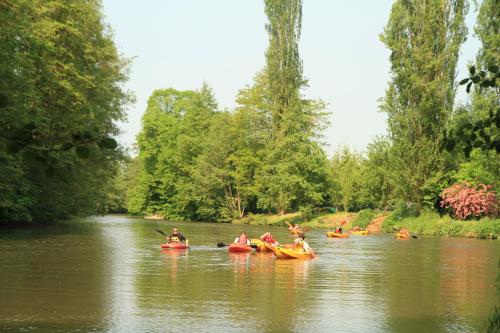 a group of people in kayaks on a river at Hotel Belle Isle Sur Risle in Pont-Audemer