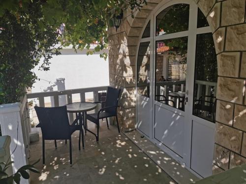 a patio with chairs and a table and a building at Holiday Resort Balota in Viganj