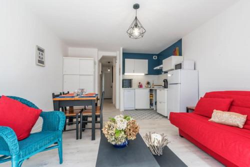 een woonkamer met een rode bank en een tafel bij KER HEDWIGE in Carnac