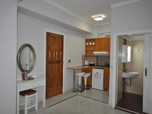 una pequeña cocina con lavabo y espejo en Apartments Chania en La Canea