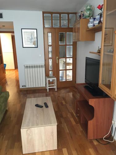 a living room with a tv and a coffee table at EL RINCÓN DE TORRENUEVA in Zaragoza