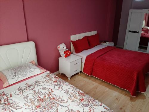 a bedroom with two beds and a teddy bear on a night stand at Samlife Apart in Samsun