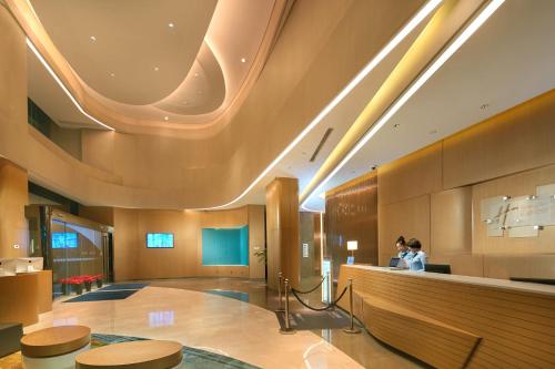 a lobby of a hotel with a reception desk and stools at Holiday Inn Express Hangzhou East Station by IHG in Hangzhou