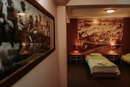 a room with two beds and a painting on the wall at Dos Patos in Ełk