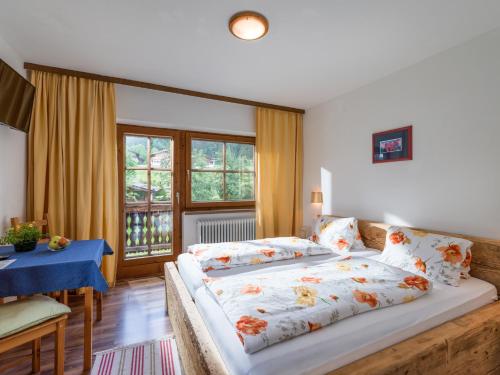 ein Schlafzimmer mit einem großen Bett und einem Tisch in der Unterkunft Weberhof Hopfgarten in Hopfgarten im Brixental