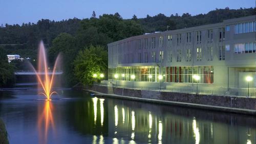 a building with a fountain in the middle of a river at Refúgio do Fujaco in São Pedro do Sul