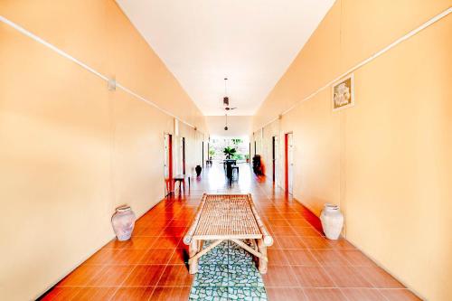 un pasillo con una mesa y jarrones en el suelo en OYO 722 I Oun Inn en Nakhon Nayok