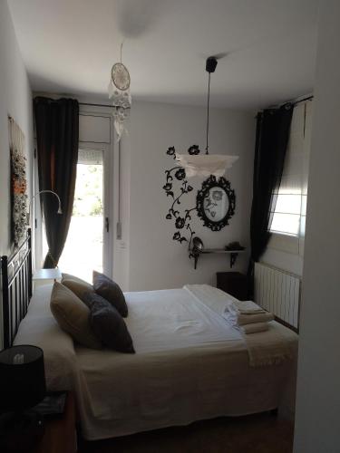a bedroom with a bed and a clock on the wall at Casa Can Miras in Comarruga