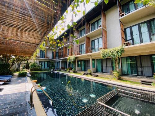 a swimming pool in front of a building at Lamphu House Chiang Mai in Chiang Mai