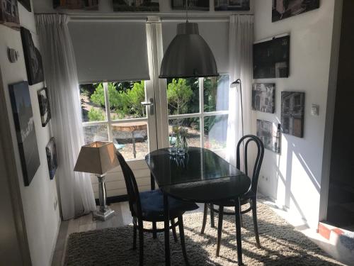 ein Esszimmer mit einem Tisch, Stühlen und einem Fenster in der Unterkunft Bed and Breakfast Azzurro in Bokhoven
