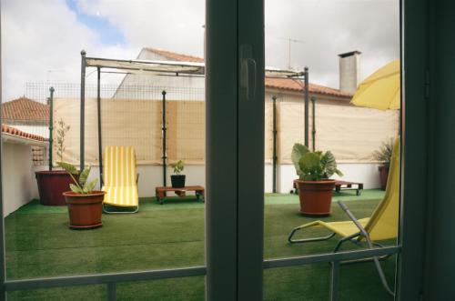a view of a patio with chairs and plants at Largo da Rainha, Guesthouse in Merciana