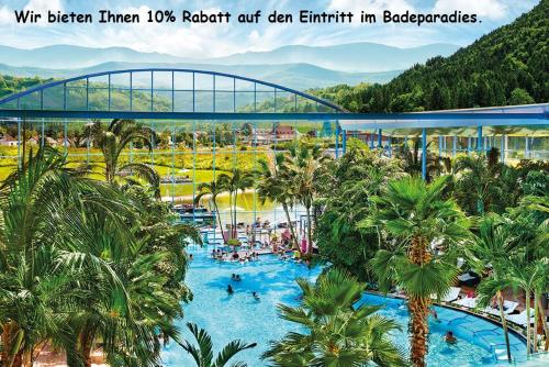 a pool at a resort with palm trees and a bridge at Hotel Hochfirst in Lenzkirch