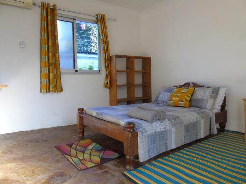 - une chambre avec un lit et une fenêtre dans l'établissement IDC Guest House, à Bagamoyo