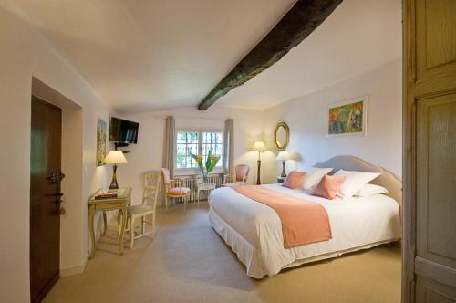 une chambre avec un lit, une table et des chaises dans l'établissement Le Mas du Chanoine, à Saint-Paul-de-Vence