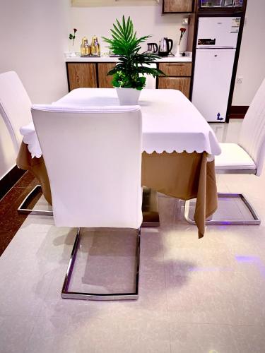 a white table with a plant on it in a kitchen at شقق حدائق الزيتون للوحدات السكنية -اقتصادية in Hail