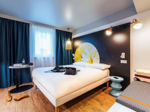 een hotelkamer met een groot bed en een tafel bij ibis Styles Le Treport Mers Les Bains in Mers-les-Bains