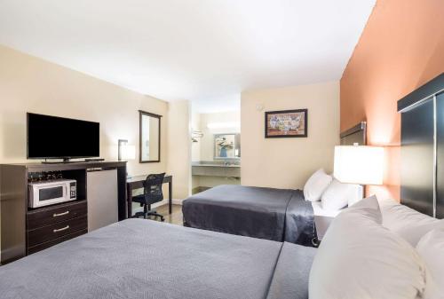 a hotel room with two beds and a flat screen tv at Econo Lodge in Santee