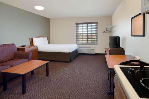 um quarto de hotel com uma cama e um sofá em WoodSpring Suites Richmond Colonial Heights Fort Gregg-Adams em Colonial Heights