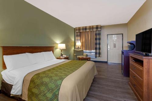 a hotel room with a bed and a television at Econo Lodge Belton - Kansas City South in Belton