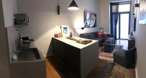 uma cozinha com um balcão e uma sala de estar em Home in Trast em Roma