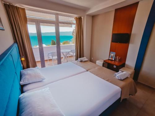 a bedroom with a large bed with a view of the ocean at Hotel & Spa Tino Sveti Stefan in Ohrid