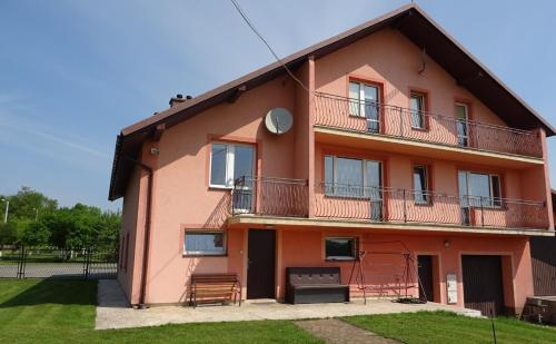 a red house with a balcony and a yard at Wynajem Pokoi dla Firm in Libiąż