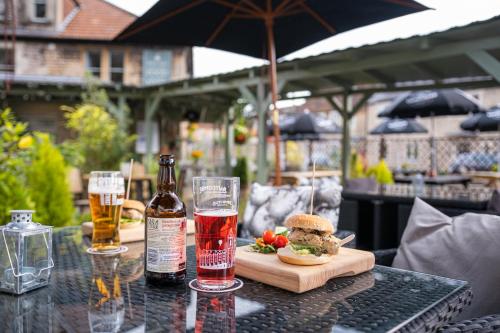 una mesa con un sándwich y dos vasos de cerveza en Rose and Crown Bath, en Hinton Charterhouse