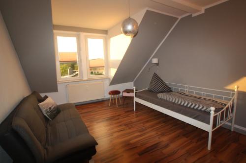 ein Schlafzimmer mit einem Bett und einem Sofa in einem Zimmer in der Unterkunft Stadtoase Zeitlos in Teterow
