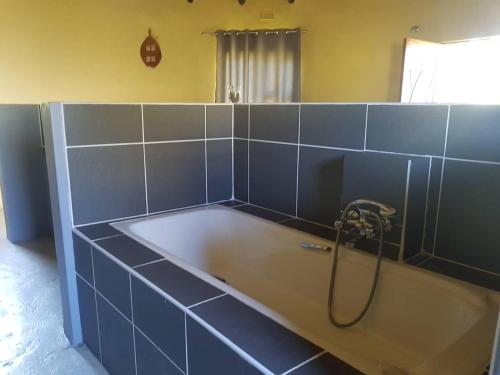 a bathroom with a bath tub with a shower at Izulu Eco Lodge in Sodwana Bay