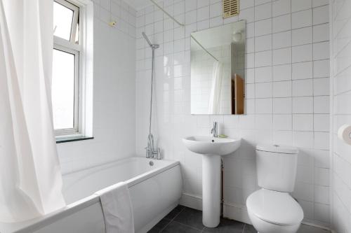 a white bathroom with a sink and a toilet and a tub at Euro Hotel Harrow in Harrow