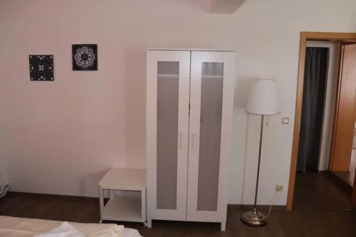 a bedroom with a white cabinet and a lamp at Wohnen am Schloß, König in Sondershausen