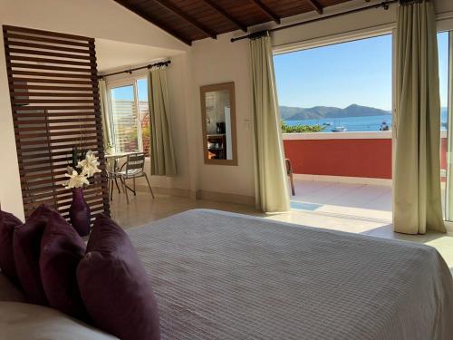 a bedroom with a bed with a view of the ocean at Mata Hari Apartamentos in Búzios