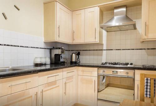 a kitchen with white cabinets and a stove top oven at Spacious 3 bedroom Beachfront property with amazing sea views! in Portsmouth