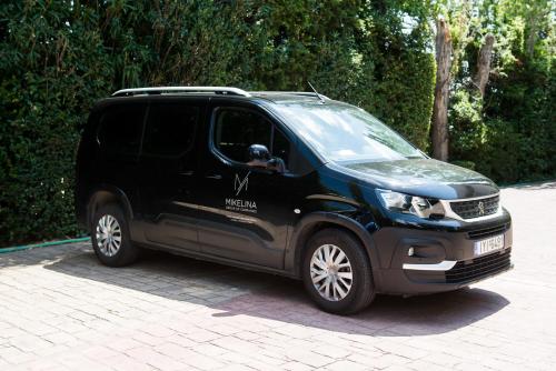 a black van parked in a parking lot at Mikelina Boutique Hotel in Pallíni