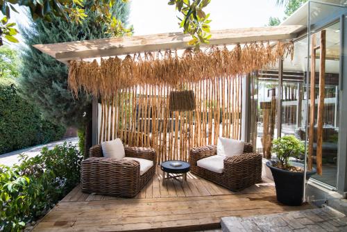 a patio with two wicker chairs and a table at Mikelina Boutique Hotel in Pallíni